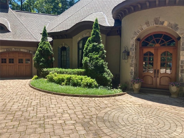 view of exterior entry featuring french doors and a garage