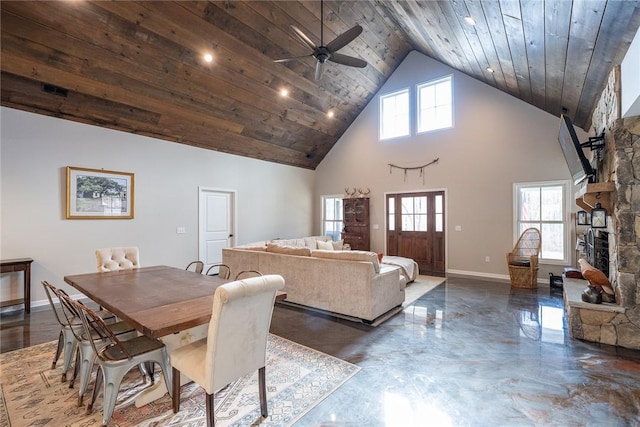 dining room featuring a stone fireplace, plenty of natural light, high vaulted ceiling, and wood ceiling