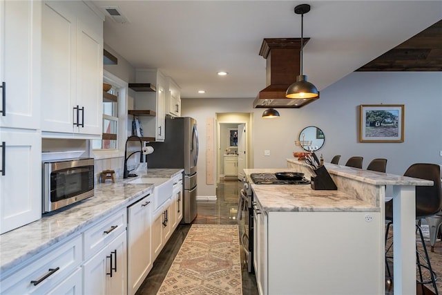 kitchen with a kitchen bar, white cabinetry, hanging light fixtures, and white range