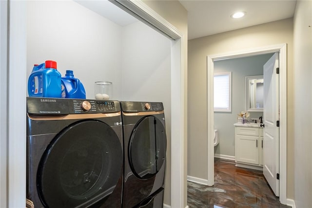 clothes washing area with independent washer and dryer and sink