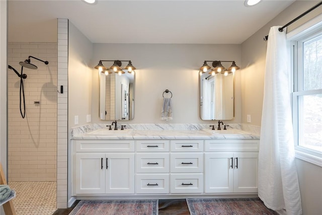 bathroom featuring tiled shower and vanity