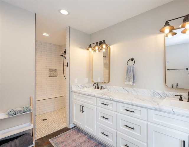 bathroom with a tile shower and vanity