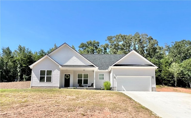 ranch-style house featuring a porch, a garage, and a front yard