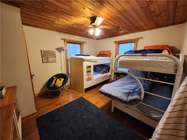 bedroom featuring multiple windows, hardwood / wood-style flooring, ceiling fan, and wooden ceiling