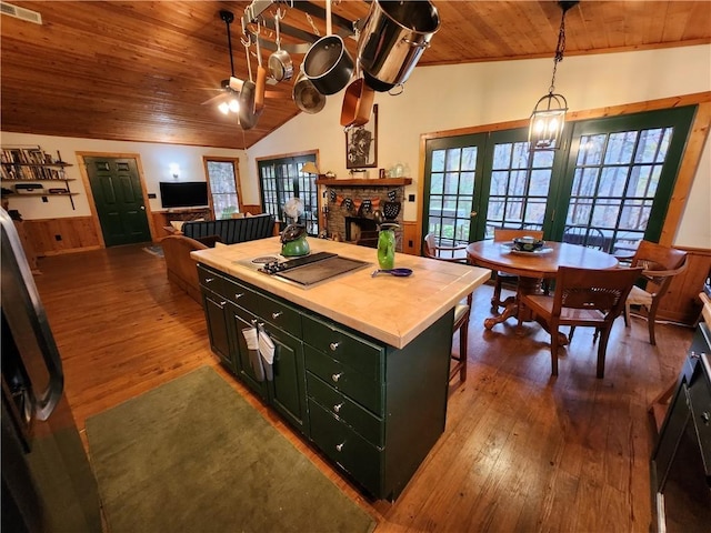 kitchen with a center island, french doors, vaulted ceiling, cooktop, and wood ceiling