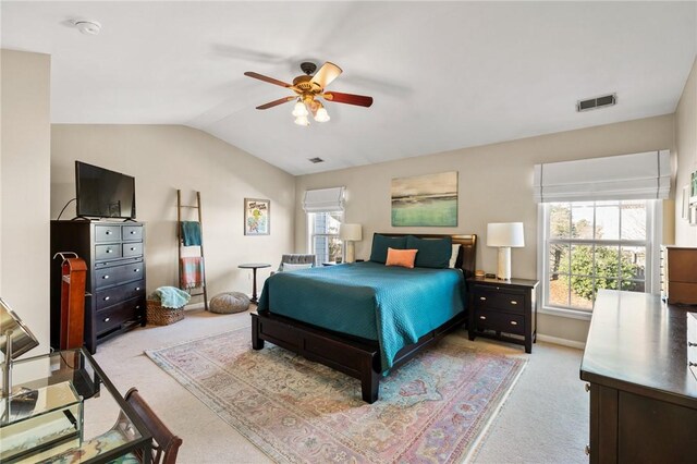 carpeted bedroom with ceiling fan and vaulted ceiling