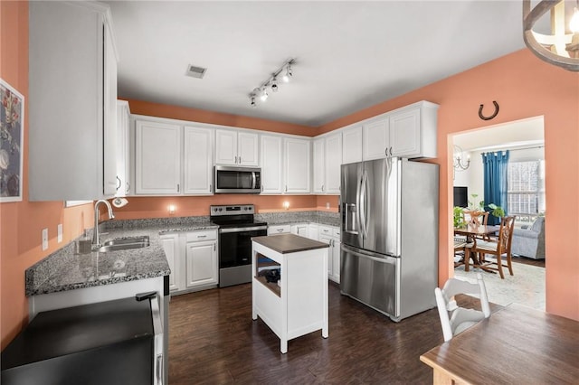 kitchen featuring white cabinets, sink, dark hardwood / wood-style floors, appliances with stainless steel finishes, and a kitchen island