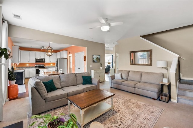 carpeted living room featuring ceiling fan and sink