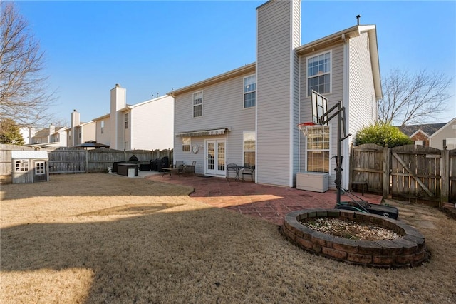 back of property featuring french doors, a patio area, and a lawn