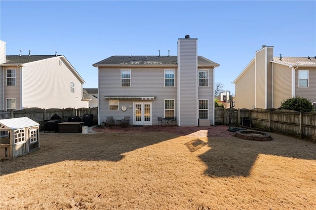 rear view of house featuring a yard and french doors