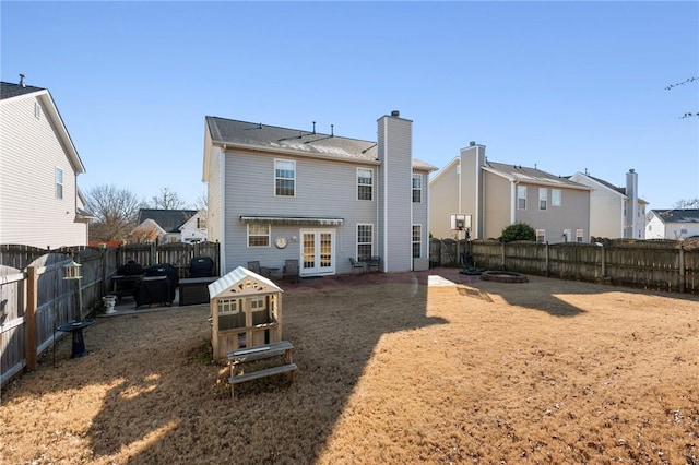 rear view of property featuring french doors and a yard