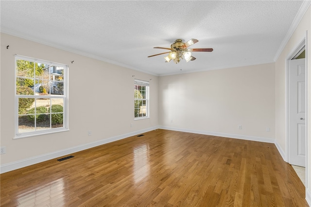 spare room featuring a textured ceiling, light wood-type flooring, and crown molding