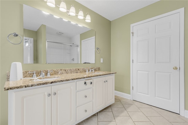 bathroom featuring tile patterned flooring, vanity, a shower with shower door, and a textured ceiling