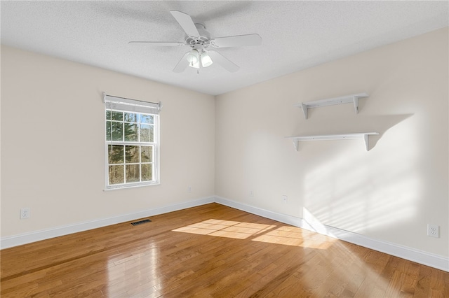 empty room with wood-type flooring, a textured ceiling, and ceiling fan