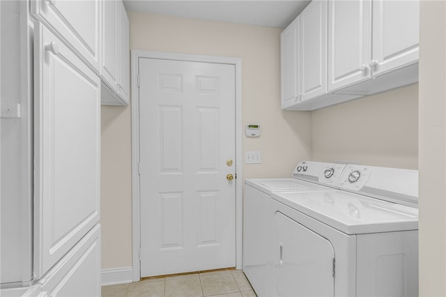 washroom with cabinets, washer and dryer, and light tile patterned flooring