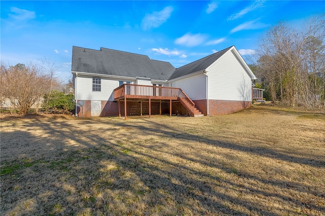 rear view of property featuring a yard and a deck