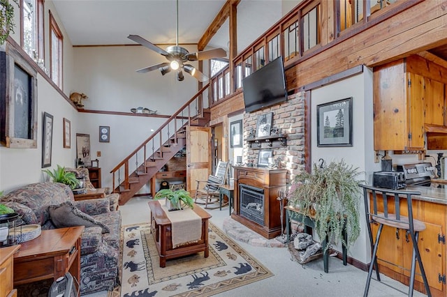 carpeted living room with ceiling fan and a towering ceiling