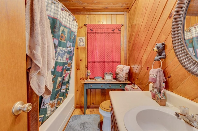 full bathroom with wood walls, shower / bath combination with curtain, vanity, toilet, and wooden ceiling