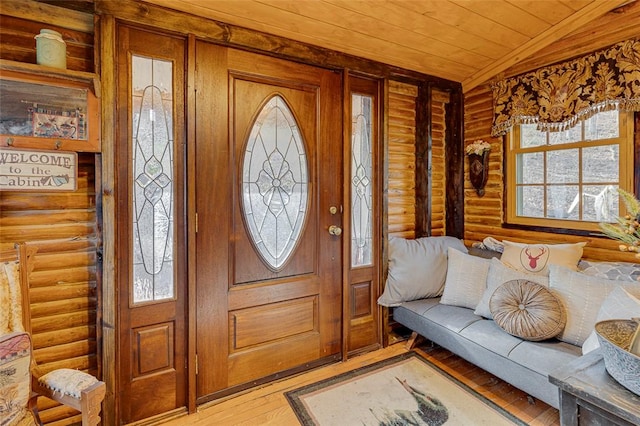 foyer entrance with light hardwood / wood-style flooring, vaulted ceiling, wood ceiling, and log walls