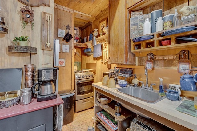 kitchen with sink, wood walls, gas stove, and wooden ceiling