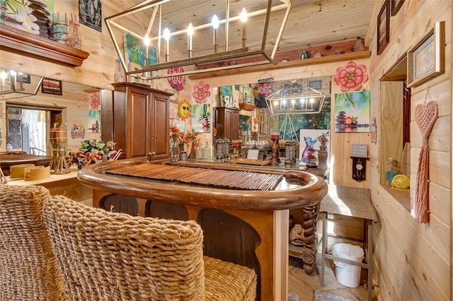 bar featuring hanging light fixtures, wooden walls, and wooden ceiling