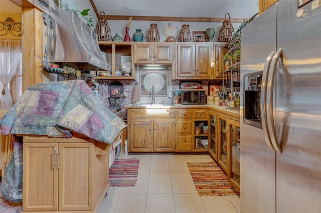 kitchen with light tile patterned floors, stainless steel fridge, a kitchen island, and sink