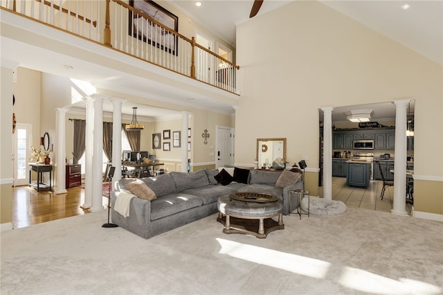 carpeted living room featuring a high ceiling and ornate columns