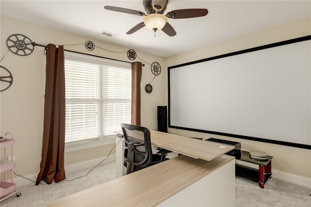 carpeted cinema room with ceiling fan and a healthy amount of sunlight