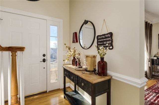 entrance foyer featuring light hardwood / wood-style flooring and crown molding