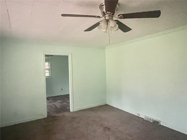 empty room featuring dark carpet, ceiling fan, and crown molding