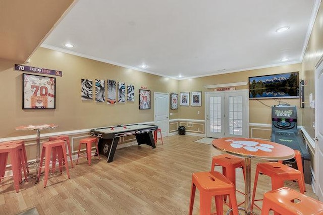 rec room featuring light hardwood / wood-style floors, ornamental molding, and french doors