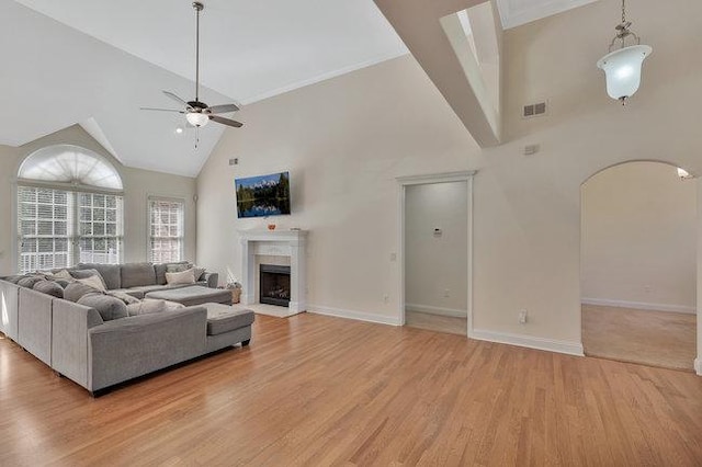 living room with ceiling fan, light wood-type flooring, and high vaulted ceiling