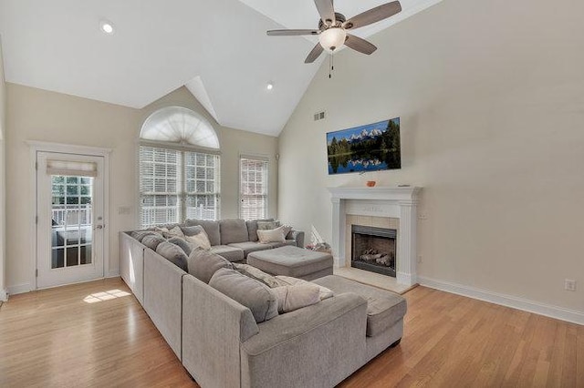 living room with light wood-type flooring, high vaulted ceiling, and ceiling fan