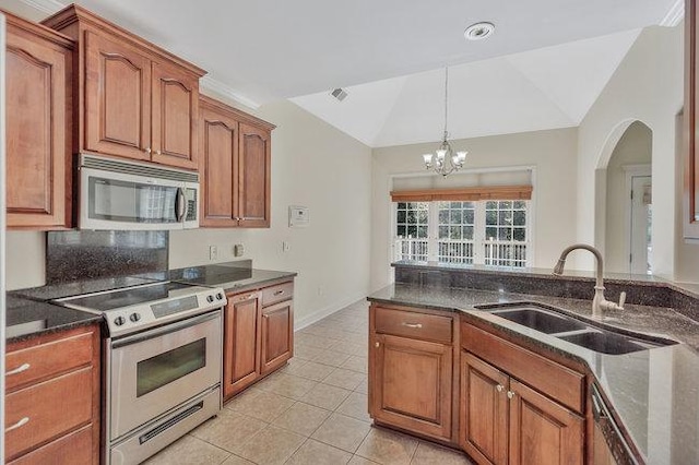 kitchen with lofted ceiling, sink, light tile patterned floors, appliances with stainless steel finishes, and a chandelier