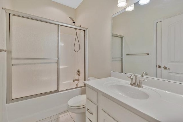 full bathroom featuring tile patterned flooring, vanity, toilet, and shower / bath combination with glass door