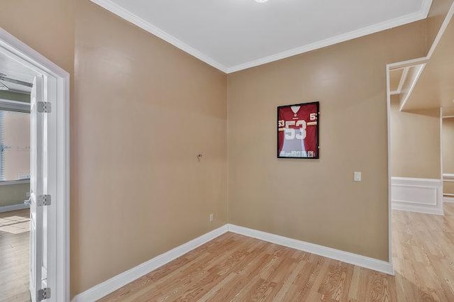 empty room with crown molding and light hardwood / wood-style floors