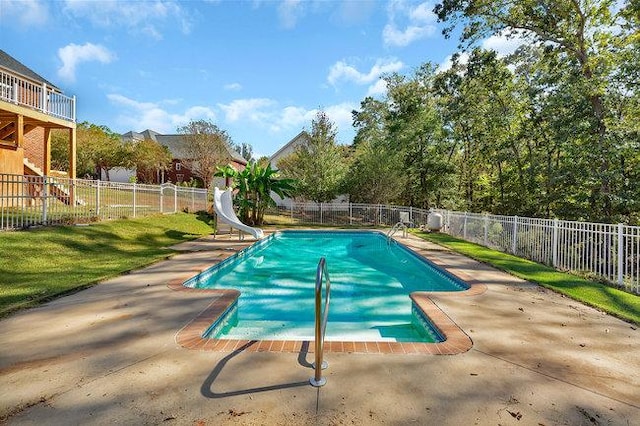 view of swimming pool featuring a yard, a patio, and a water slide