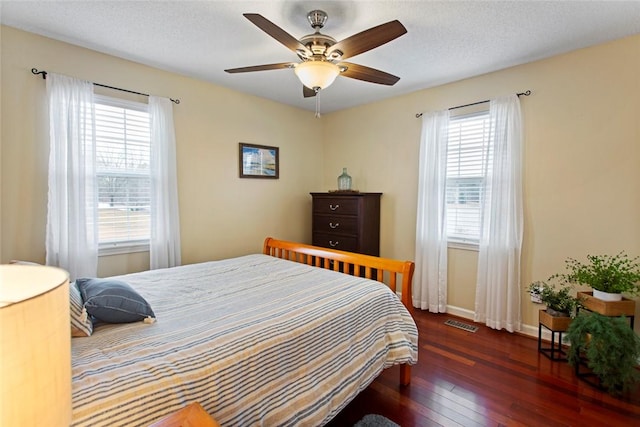 bedroom featuring multiple windows, hardwood / wood-style flooring, visible vents, and baseboards