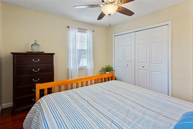 bedroom featuring baseboards, a ceiling fan, dark wood finished floors, and a closet