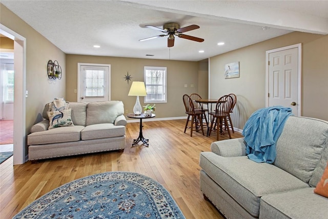 living room with visible vents, baseboards, a ceiling fan, light wood-style floors, and recessed lighting