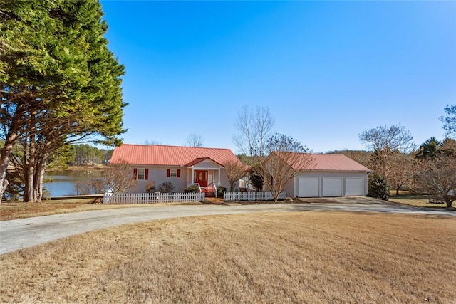 ranch-style house with a fenced front yard, covered porch, a front yard, metal roof, and a garage