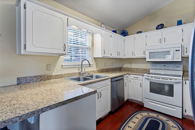 kitchen with white appliances, dark wood-style flooring, vaulted ceiling, white cabinetry, and a sink