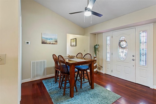 dining space featuring baseboards, visible vents, vaulted ceiling, and hardwood / wood-style floors