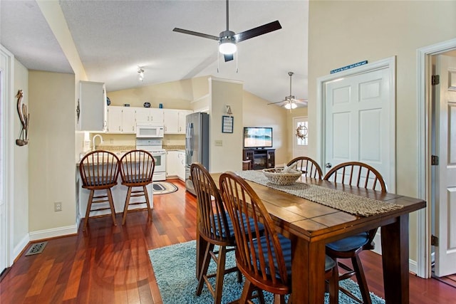 dining area featuring lofted ceiling, dark wood finished floors, a ceiling fan, and baseboards