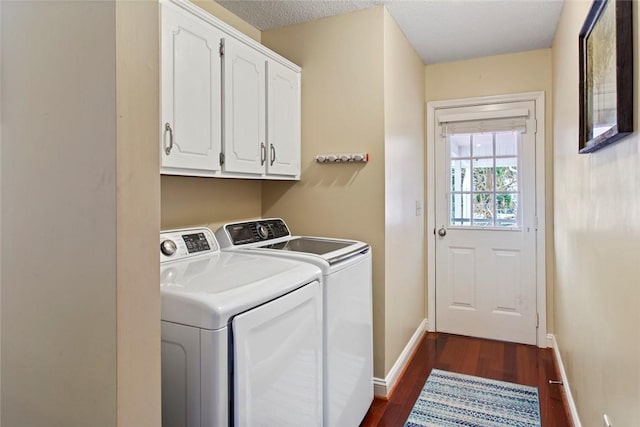 laundry room with a textured ceiling, baseboards, washer and dryer, cabinet space, and dark wood-style floors