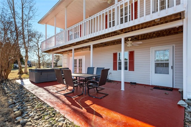 view of patio featuring french doors, outdoor dining area, a ceiling fan, and a hot tub