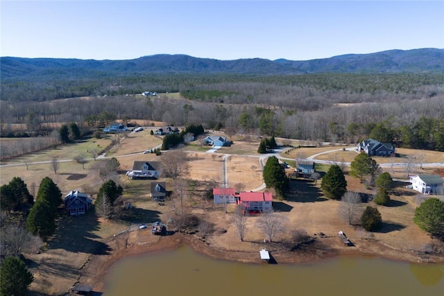 drone / aerial view featuring a wooded view and a mountain view