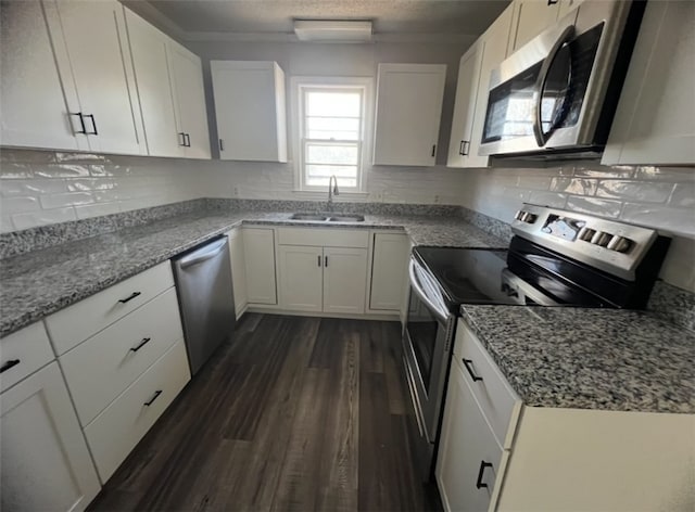 kitchen featuring white cabinetry, sink, light stone counters, and appliances with stainless steel finishes