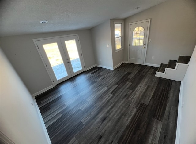 entryway with a textured ceiling, french doors, dark hardwood / wood-style floors, and vaulted ceiling