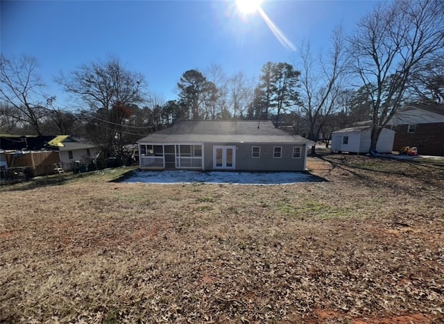 rear view of property with a yard, a sunroom, and french doors